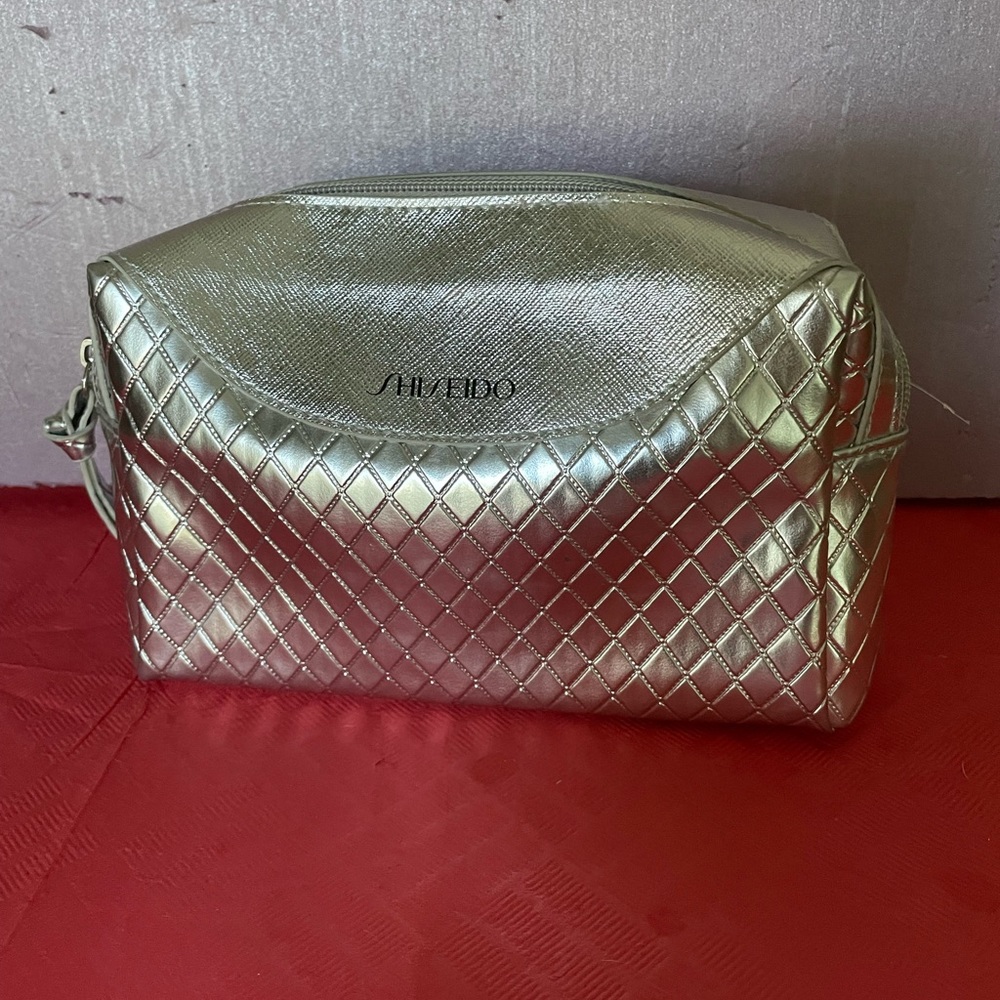 Shiseido cosmetics bag. Color silver. Zipper closure.